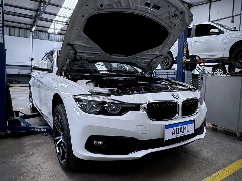 BMW com capô aberto no box de serviço